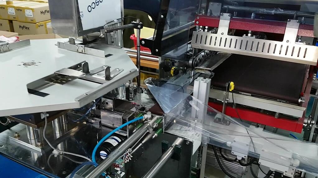 Auto glove folding and shrink wrap machine